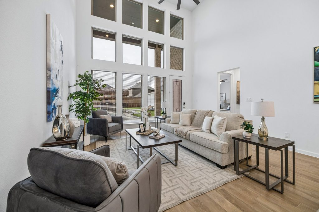 Living room with 19-foot ceilings and stacked windows at 14 Savory Saute Dr, a Harvest Green home for sale